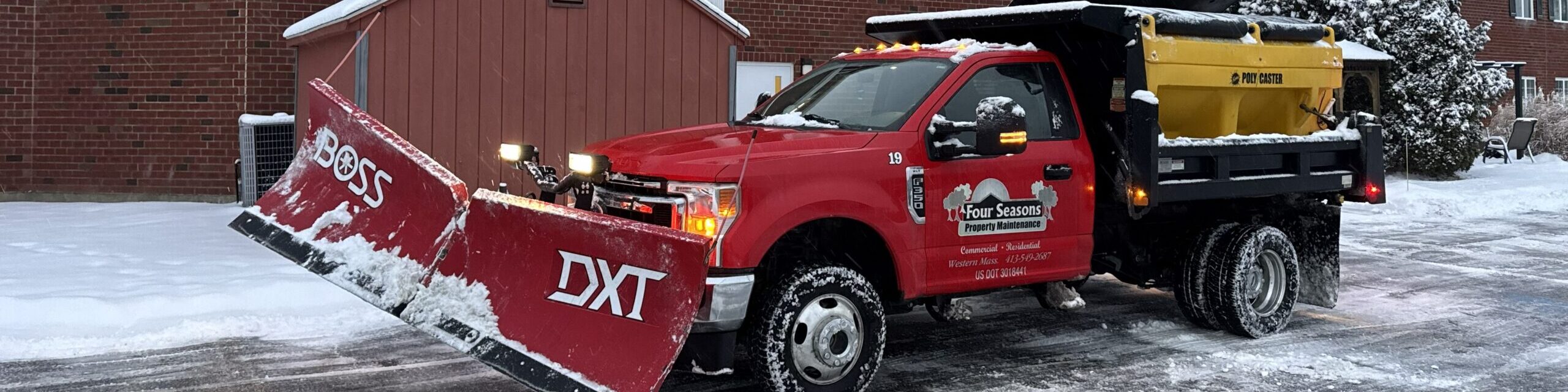 Four Seasons Property Maintenance plow and salt truck clearing snow at a commercial apartment complex in Western Massachusetts
