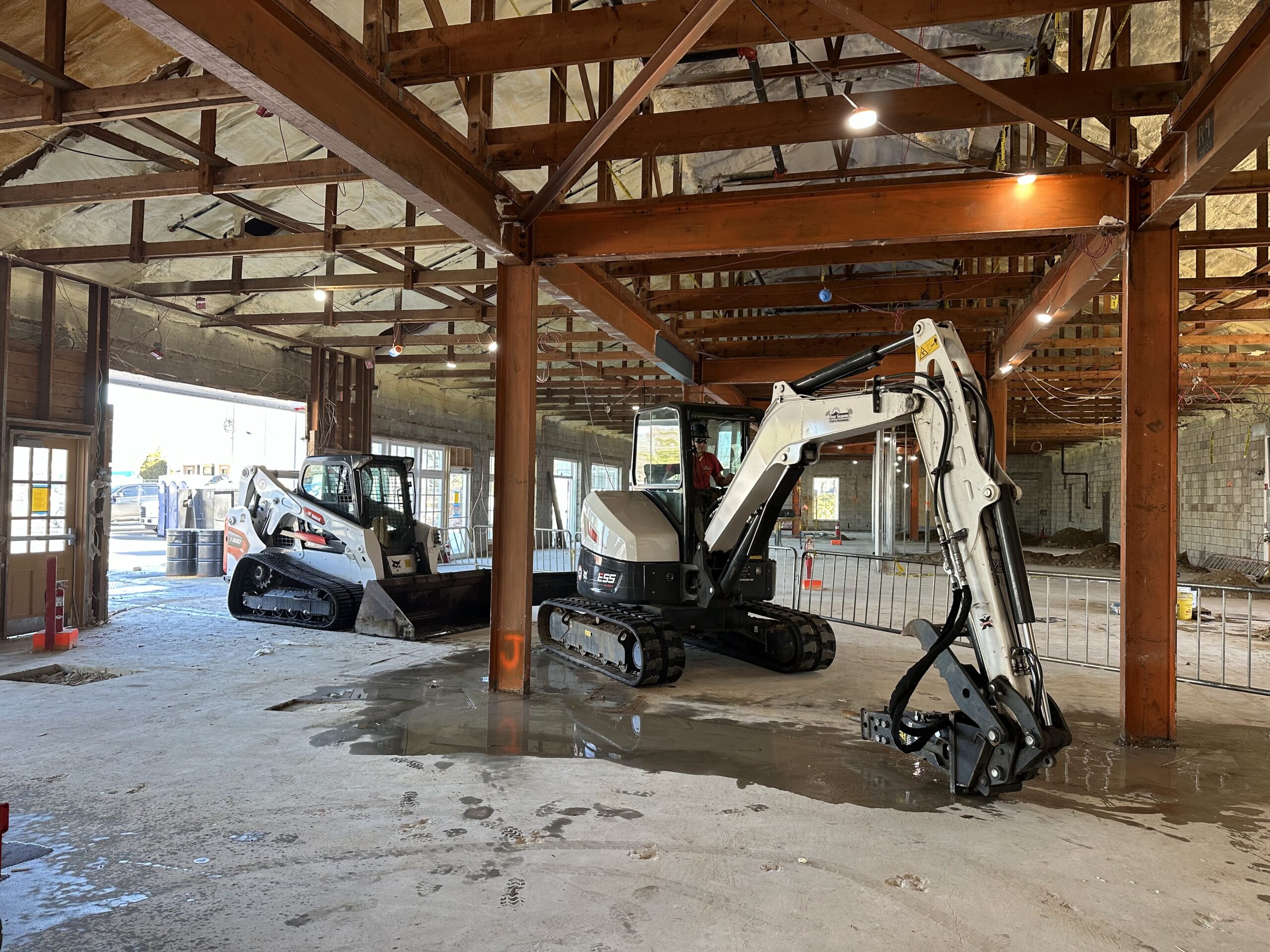 Four Seasons Property Maintenance heavy construction equipment inside a commercial metal building project in Western Massachusetts